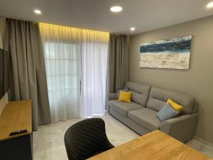 ein Wohnzimmer mit einem Sofa und einem Tisch in der Unterkunft Luxury Diamond - Ocean view, Big terraces, Air Con, Wifi in Los Cristianos