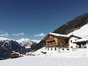 eine Skihütte im Schnee mit Bergen im Hintergrund in der Unterkunft BERG(hof) in Pfunds