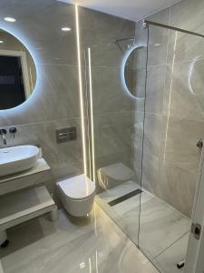uma casa de banho com um chuveiro, um WC e um lavatório. em Luxury Diamond - Ocean view, Big terraces, Air Con, Wifi em Los Cristianos