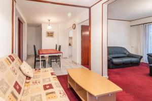 ein Wohnzimmer mit einem Sofa und einem Tisch in der Unterkunft Marmottes Furnished flat in Annecy