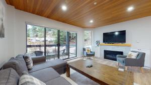 a living room with a couch and a tv at Ironwoods on Blueberry Hill by Whistler Blackcomb Vacation Rentals in Whistler