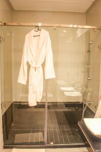 拉巴特的住宿－YourPlace - Luxury - Prestigia Hay Riad，浴室里挂在玻璃盒上的长袍