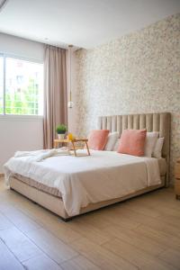 een slaapkamer met een groot wit bed met roze kussens bij YourPlace - Luxury - Prestigia Hay Riad in Rabat