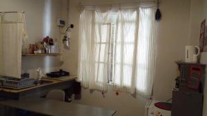 kuchnia ze zlewem oraz okno z białymi zasłonami w obiekcie Loft Rufino w mieście Mendoza