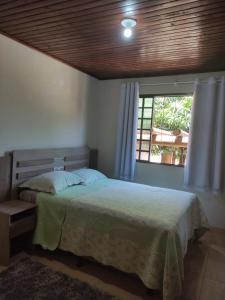 a bedroom with a bed and a window at Suíte Maciel in Foz do Iguaçu