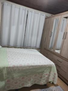 Schlafzimmer mit einem Bett, einer Kommode und einem Fenster in der Unterkunft Suíte Maciel in Foz do Iguaçu