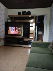 a living room with a flat screen tv on a entertainment center at Suíte Maciel in Foz do Iguaçu