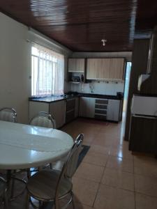 eine Küche mit einem Tisch und Stühlen im Zimmer in der Unterkunft Suíte Maciel in Foz do Iguaçu
