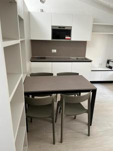 una cucina con tavolo da pranzo e sedie di Smart Apartments Palazzo Mazzini a Rovereto