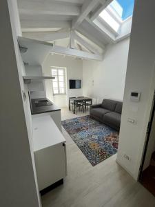 a kitchen and living room with a couch and a table at Smart Apartments Palazzo Mazzini in Rovereto