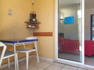 a table and chairs in a room with a glass door at Aquabeach in La Saline les Bains