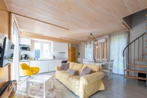 ein Wohnzimmer mit einem Sofa und einer Küche in der Unterkunft Osada Rybacka in Kopalino