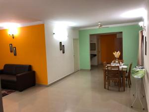 a living room with a table and a dining room at Bulande Comforts-Service Apartment In Brookfield in Bangalore