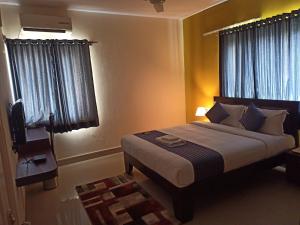 a bedroom with a large bed and a window at Bulande Comforts-Service Apartment In Brookfield in Bengaluru