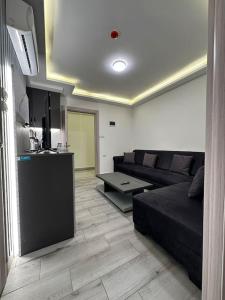 uma sala de estar com um sofá preto e uma cozinha em privet (33)near downtown kh&sh em Ash Shumaysānī