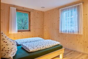 1 dormitorio con cama y ventana en Mittnackerhof Apartment Ringelblume, en Sarentino