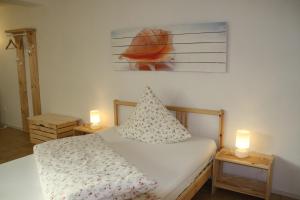 a bedroom with a bed with two candles on two tables at Hotel Anchovis in Mönchengladbach