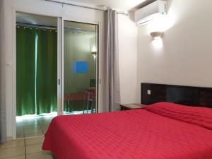 a bedroom with a red bed and a sliding glass door at Aquabeach in La Saline les Bains