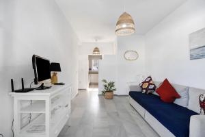 ein Wohnzimmer mit einem Sofa und einem TV in der Unterkunft Apartamento Calas Sancti Petri in Novo Sancti Petri