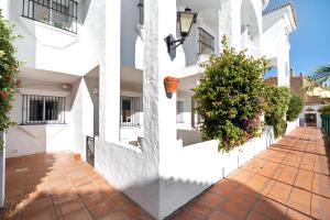 two images of a white building with a courtyard at Apartamento Calas Sancti Petri in Novo Sancti Petri