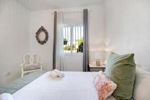 a bedroom with a bed and a chair and a window at Apartamento Calas Sancti Petri in Novo Sancti Petri +23 photos