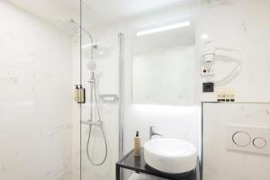 baño blanco con ducha y lavamanos en Huygens Place Amsterdam, en Ámsterdam