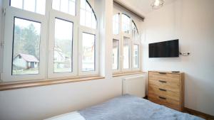 Televízia a/alebo spoločenská miestnosť v ubytovaní Apartamenty EverySky - Saneczkowa 3