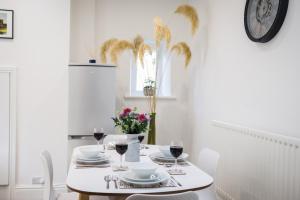 uma sala de jantar branca com uma mesa com copos de vinho em The Old Packhorse em Staindrop