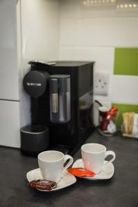 The Old Packhorse في Staindrop: وجود كوبين من القهوة على منضدة بجوار آلة صنع القهوة
