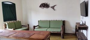 uma sala de estar com duas cadeiras verdes e uma mesa em Casa do Renato Lençóis em Lençóis