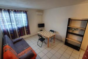 un soggiorno con un divano e un tavolo di 972D6 - Kaymit - Studio 20m2 a Schœlcher