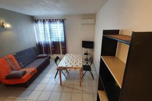 un soggiorno con un divano e un tavolo di 972D6 - Kaymit - Studio 20m2 a Schœlcher