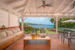 une terrasse avec un canapé, une table et des chaises dans l'établissement Villas Manzelle - Luxury villas on the beach, au Vauclin