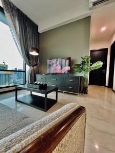 EUcation Home - Opus Residence في كوالالمبور: غرفة معيشة مع أريكة وتلفزيون
