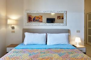 1 dormitorio con 1 cama con 2 almohadas y espejo en Casa al Viminale, en Roma