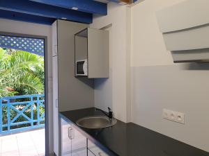 a bathroom with a sink and a counter with a window at Aquabeach in La Saline les Bains