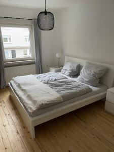 1 cama blanca en un dormitorio con ventana en Apartment Wostspitze en Bochum