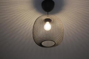 une lampe suspendue au plafond dans une pièce dans l'établissement Apartment Wostspitze, à Bochum