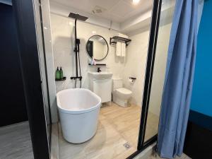 a bathroom with a bath tub and a toilet at LuLu Inn in Tainan