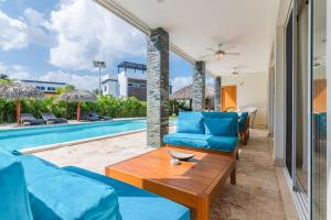 - un salon doté d'un mobilier bleu à côté de la piscine dans l'établissement 4 bedroom villa Sosua Ocean Village Las Palmas, à Sosúa