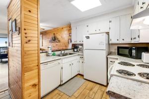a kitchen with white appliances and wooden walls at Mountain Top Retreat in Gatlinburg
