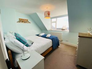 a bedroom with a bed and a table and a window at Kearney Cottage - Artist's Retreat in Portland