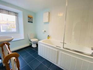 a bathroom with a tub and a toilet and a sink at Kearney Cottage - Artist's Retreat in Portland +25 photos
