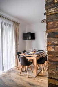 - une salle à manger avec une table et des chaises en bois dans l'établissement Modrzewiowa Ostoja, à Kluszkowce