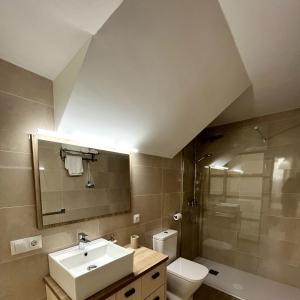 a bathroom with a sink and a toilet and a shower at Apartamentos turísticos CASA de los BALCONES in Chipiona