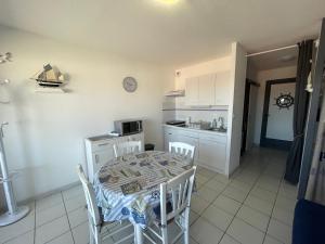 a kitchen and dining room with a table and chairs at Le Surf in Mimizan-Plage