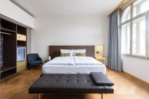um quarto com uma cama grande e um banco preto em numa I Laurel em Praga