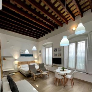 ein Wohnzimmer mit einem Sofa und einem Tisch in der Unterkunft Apartamentos turísticos CASA de los BALCONES in Chipiona