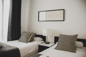 A bed or beds in a room at AZZ Sevilla Torre de la Plata Apartamentos