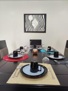 グアヤキルにあるLola's House Guayaquil Self Check-In & B&Bの黒いテーブル(皿、メガネ付)